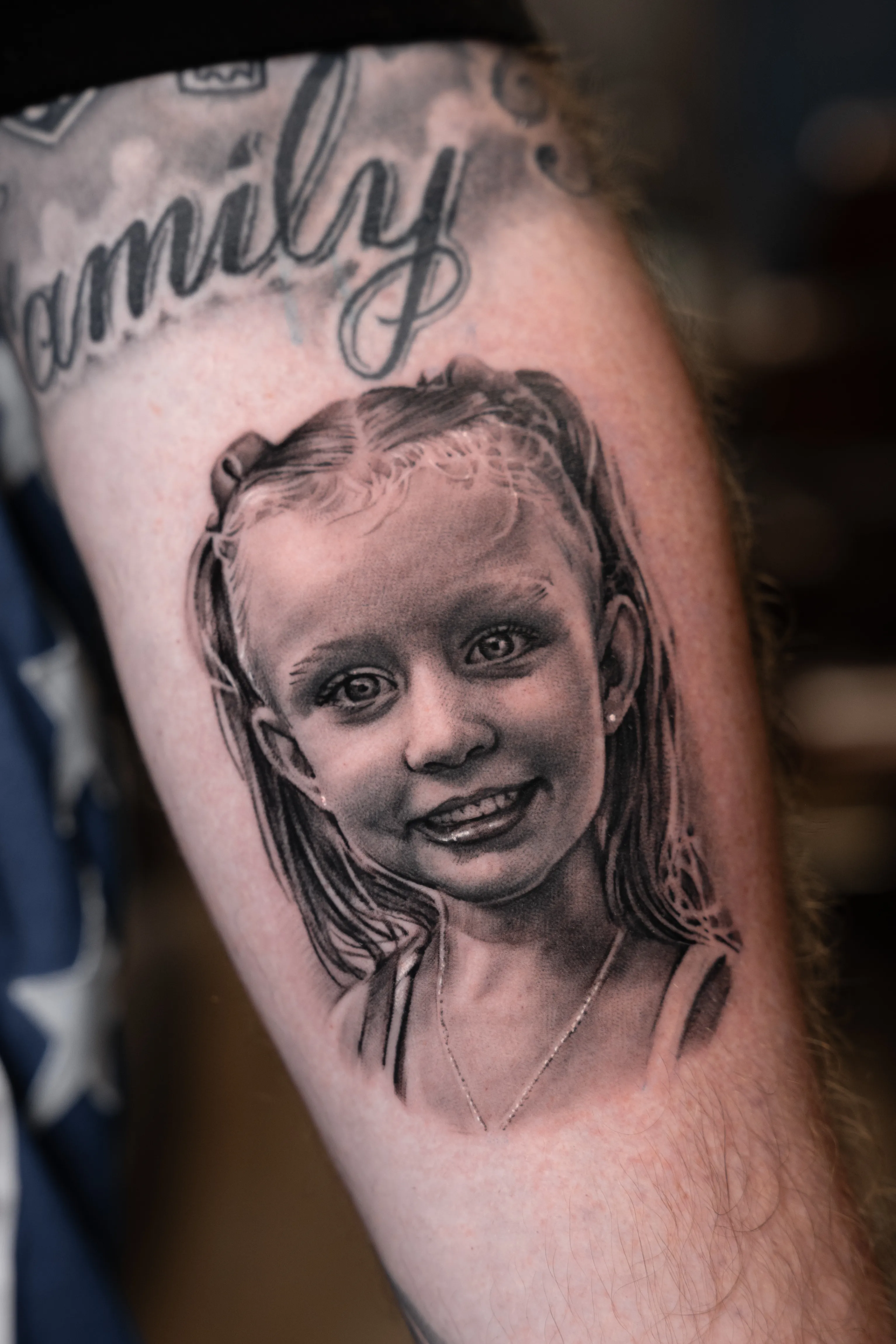 Black-and-grey realism portrait of a young girl, soft photographic detail — TKOTATTOO Fort Lauderdale